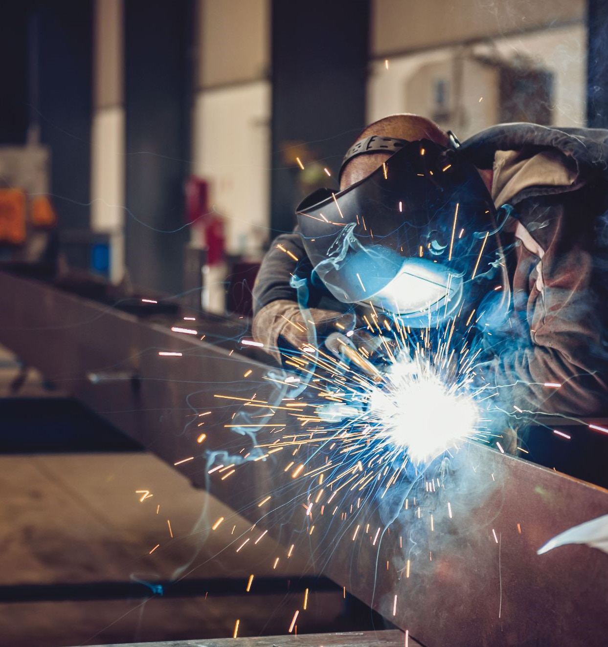 Soldador trabajando en fabricación de estructura metálica
