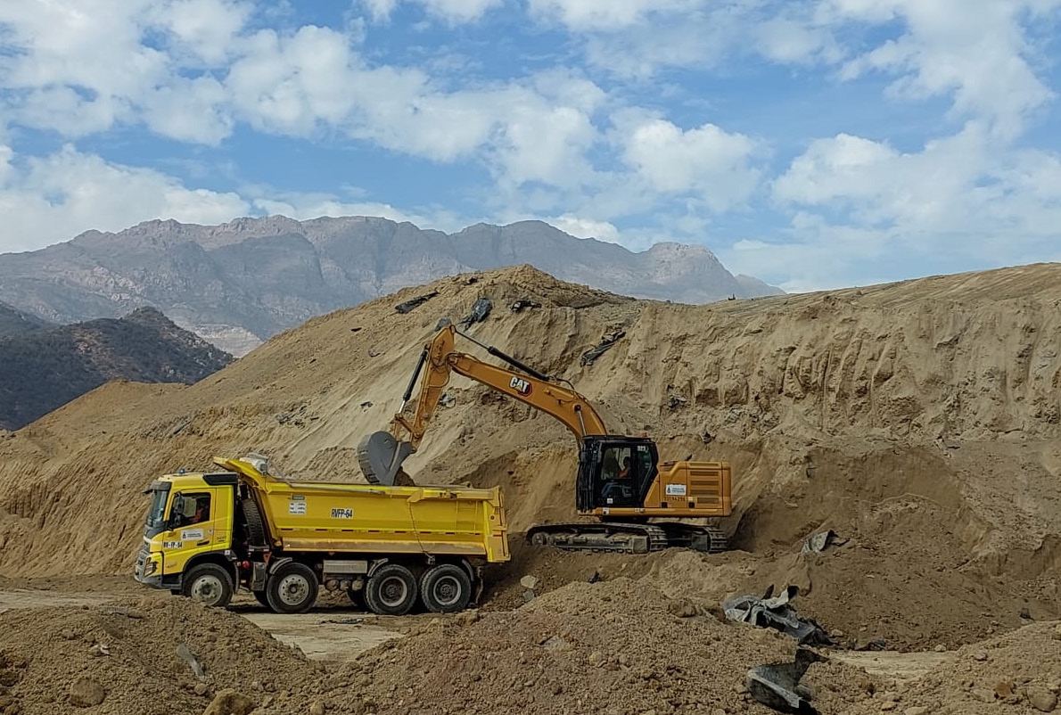 Excavadora y camión tolva trabajando en preparación de plataforma